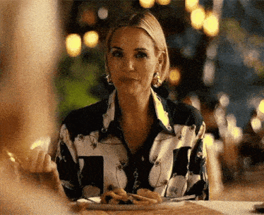 a woman is sitting at a table eating food from a plate .