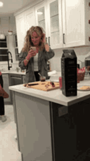 a woman is taking a picture of herself in the kitchen