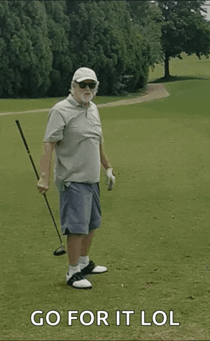 an elderly man is holding a golf club on a golf course with the words go for it lol below him