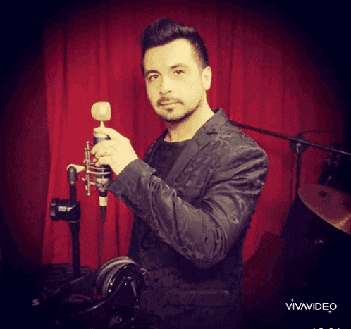 a man in a black jacket is holding a microphone
