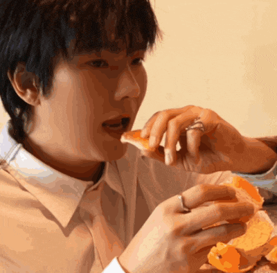 a man with a ring on his finger is eating a piece of food
