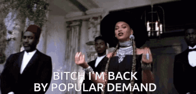 a woman in a black hat says bitch i 'm back by popular demand in front of a group of men in tuxedos