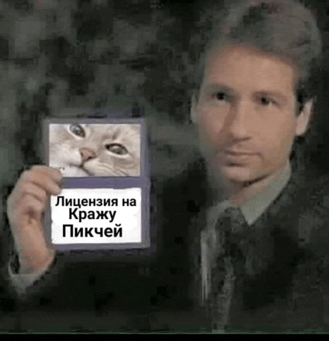 a man in a suit and tie is holding a picture of a cat on a piece of paper .