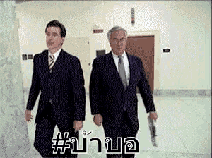two men in suits and ties are walking down a hallway with a hashtag # on the floor