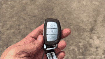 a person holding a car key that says push