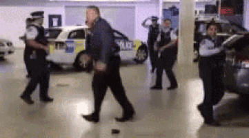 a group of police officers are walking around a parking garage .