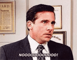 a man in a suit and tie is making a funny face and saying no .