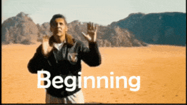 a man is standing in the desert with the word beginning behind him