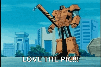 a cartoon robot is standing in front of a city with the words `` love the pic '' written on it .