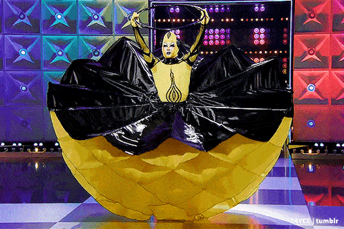 a woman in a yellow and black dress is holding a hoop