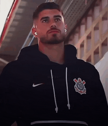 a man with a beard wears a nike hoodie