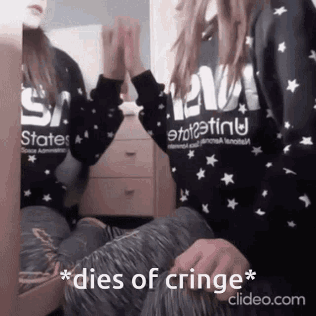 a girl sitting in front of a mirror wearing a sweater that says states on it