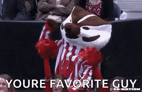 a mascot is wearing a red and white uniform and cheering in a crowd with the words `` youre favorite guy '' .