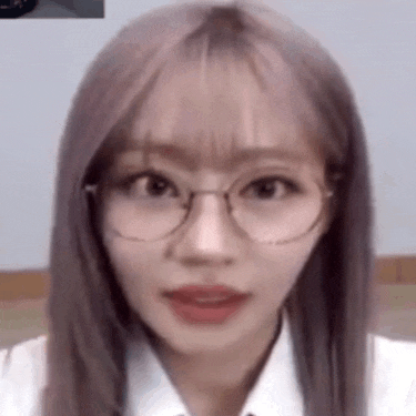 the girl is wearing glasses and a white shirt .