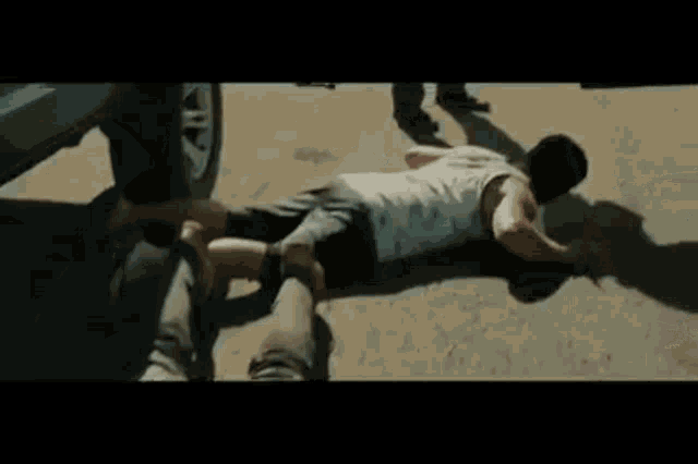 a man is laying on the ground while a police officer stands next to him .