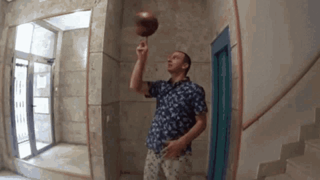 a man in a floral shirt is juggling a basketball