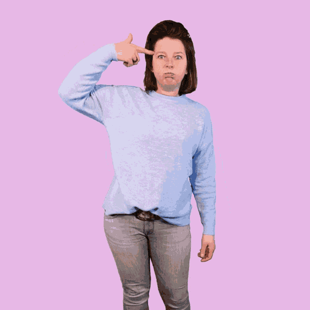 a woman in a blue sweater and jeans is making a face