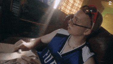 a man wearing sunglasses and a blue jersey that says futura