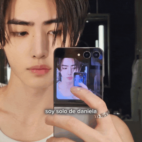 a man taking a picture of himself with the words soy solo de daniela on the bottom right