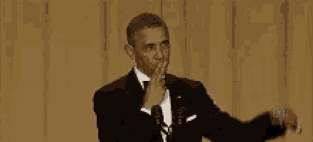 barack obama is wearing a tuxedo and bow tie while standing in front of a microphone on a stage .