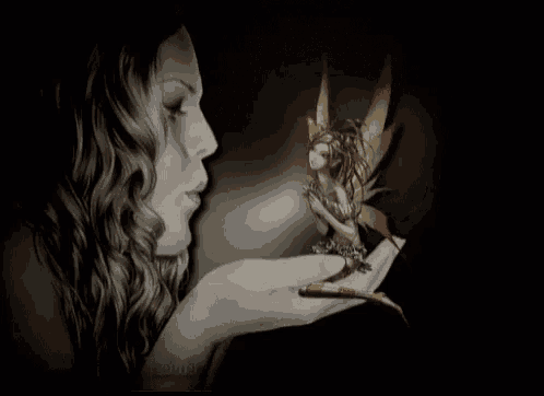 a woman is holding a statue of a fairy in her hands .