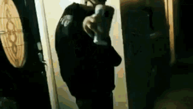 a man is holding a gun in a dark room .
