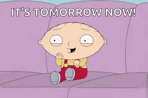 a cartoon character is sitting on a couch with the words `` it 's tomorrow now '' .