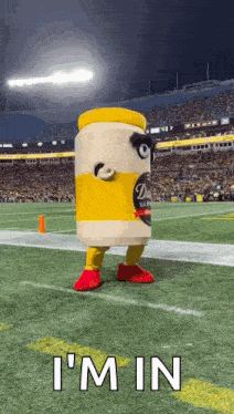 a jar of mayonnaise mascot is standing on a football field .