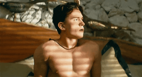 a shirtless man is sitting on a bed with his eyes closed and a necklace around his neck .
