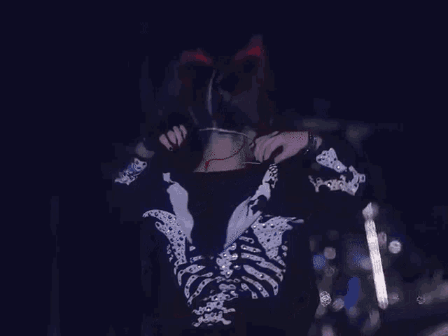 a woman in a skeleton costume is singing into a microphone