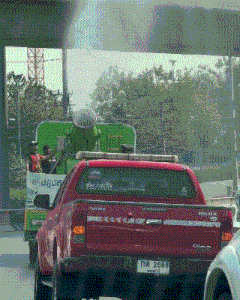 a red toyota hilux truck is driving down a street