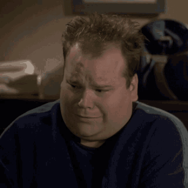 a man in a blue sweater says " ah non " in front of his face