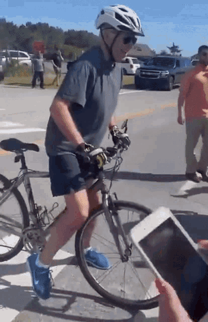 a man wearing a helmet is riding a bike on a street
