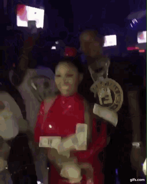 a woman in a red dress is dancing with a man holding money