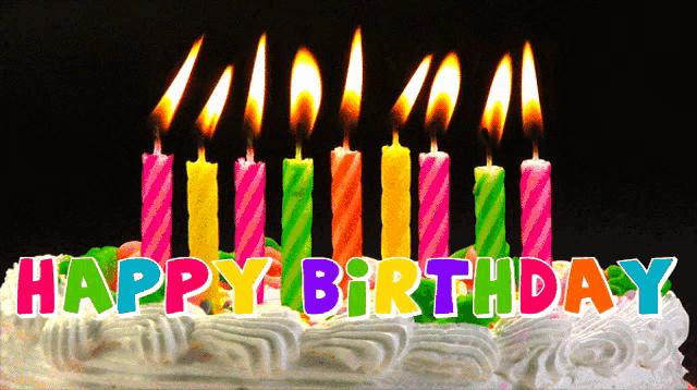 a birthday cake with colorful candles that says happy birthday