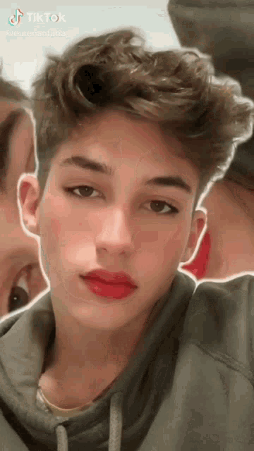 a young man with red lipstick on his lips