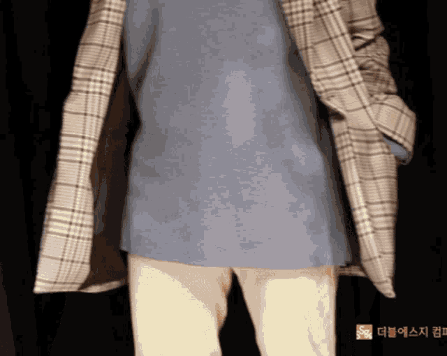 a person wearing a plaid jacket and a gray shirt