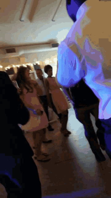 a group of people are dancing in a room