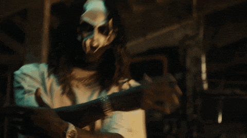 a man with long hair and a mask on his face is wearing a watch