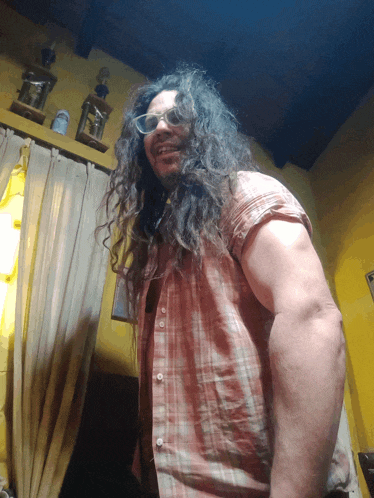a man with long curly hair is wearing glasses