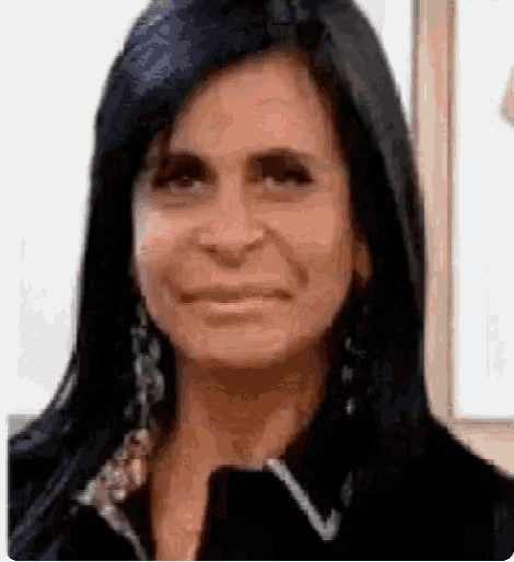 a close up of a woman 's face with black hair and earrings .