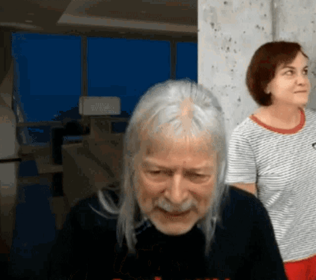 a man with gray hair and a mustache is wearing a shirt that says ' i love you '