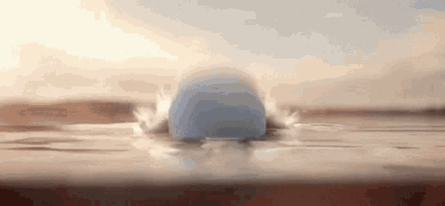 a blue ball is floating on top of a brown surface in the water .