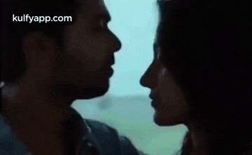 a man and a woman are kissing in front of a window on a train .