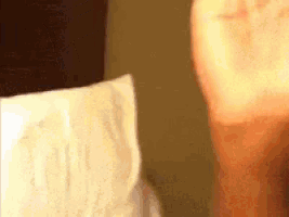 a close up of a person 's face with a roll of toilet paper in the background