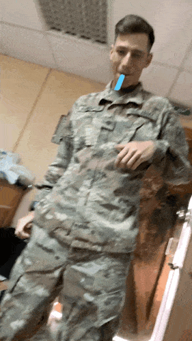 a man in a military uniform has a blue toothbrush in his mouth