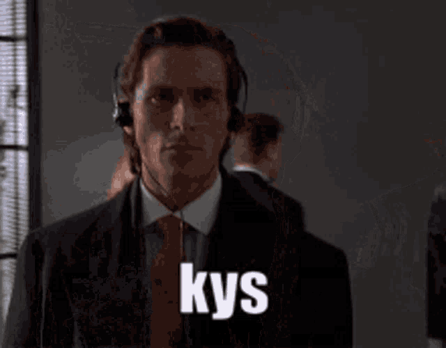 a man in a suit and tie is wearing headphones and has the word kys on his face