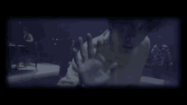 a man in a yellow sweater is reaching out towards the camera