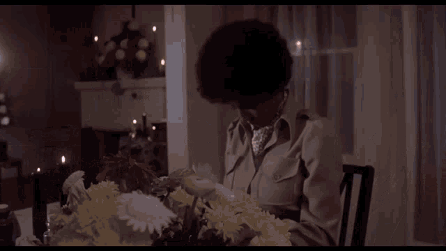 a man sitting in front of a coffin with candles in front of it