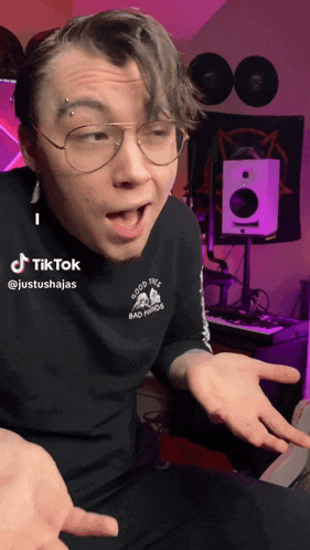 a man wearing glasses and a black shirt that says good this bad period